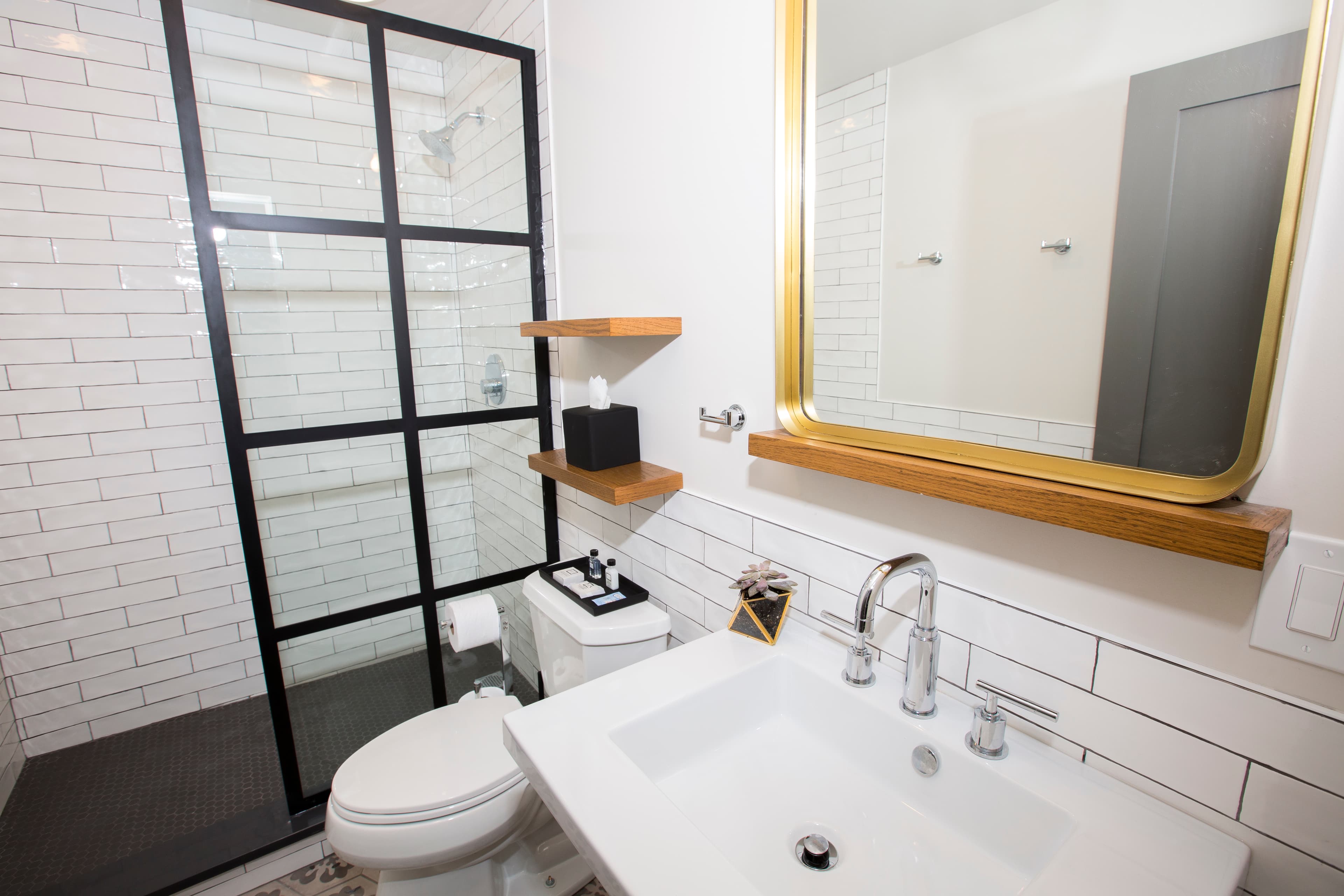 Damen's ensuite bathroom, showing the shower wall, the large sink and complimentary toiletries.