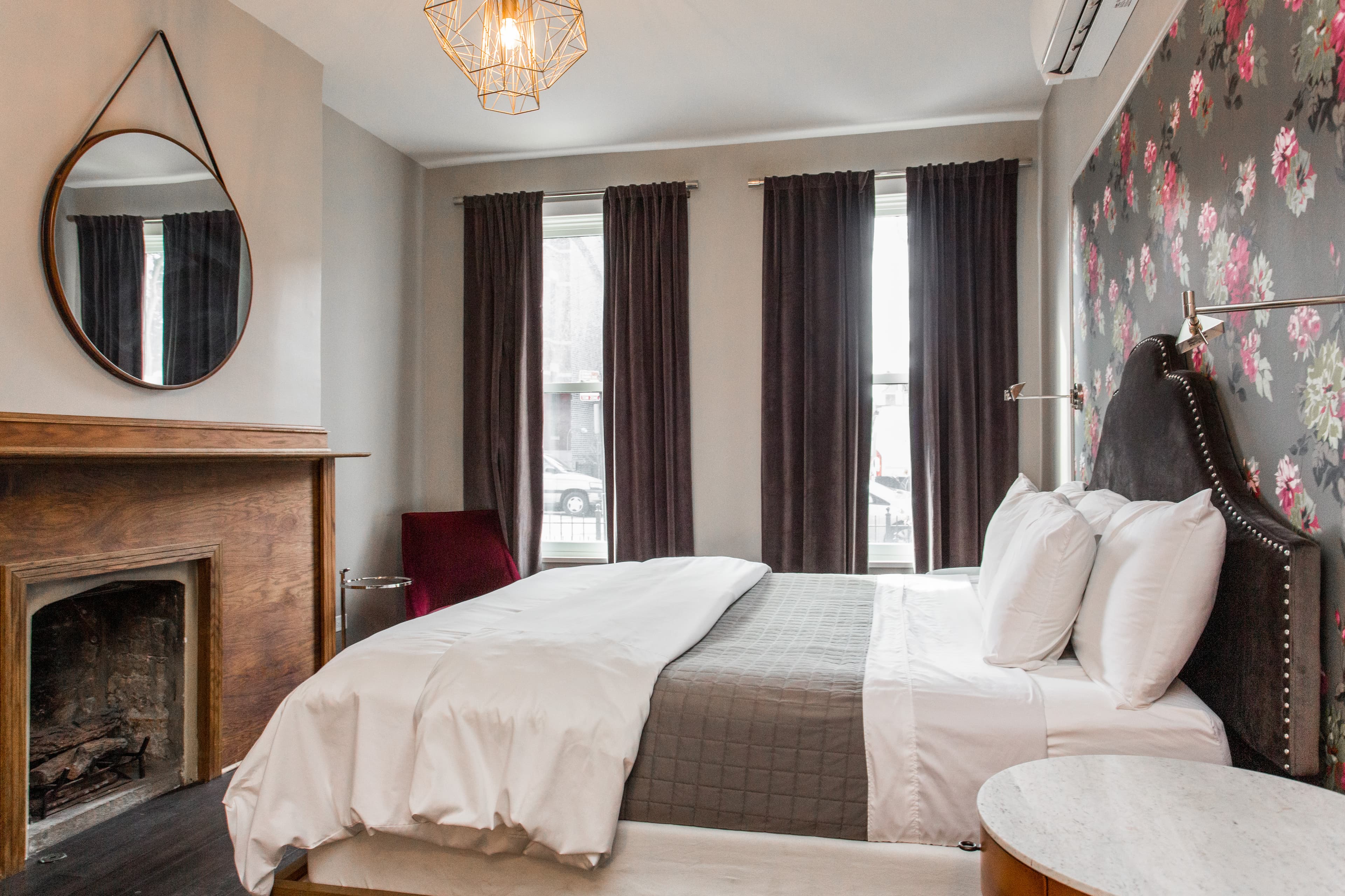 The Hoyne King bedroom, including a sprawling bed and wooden hearth