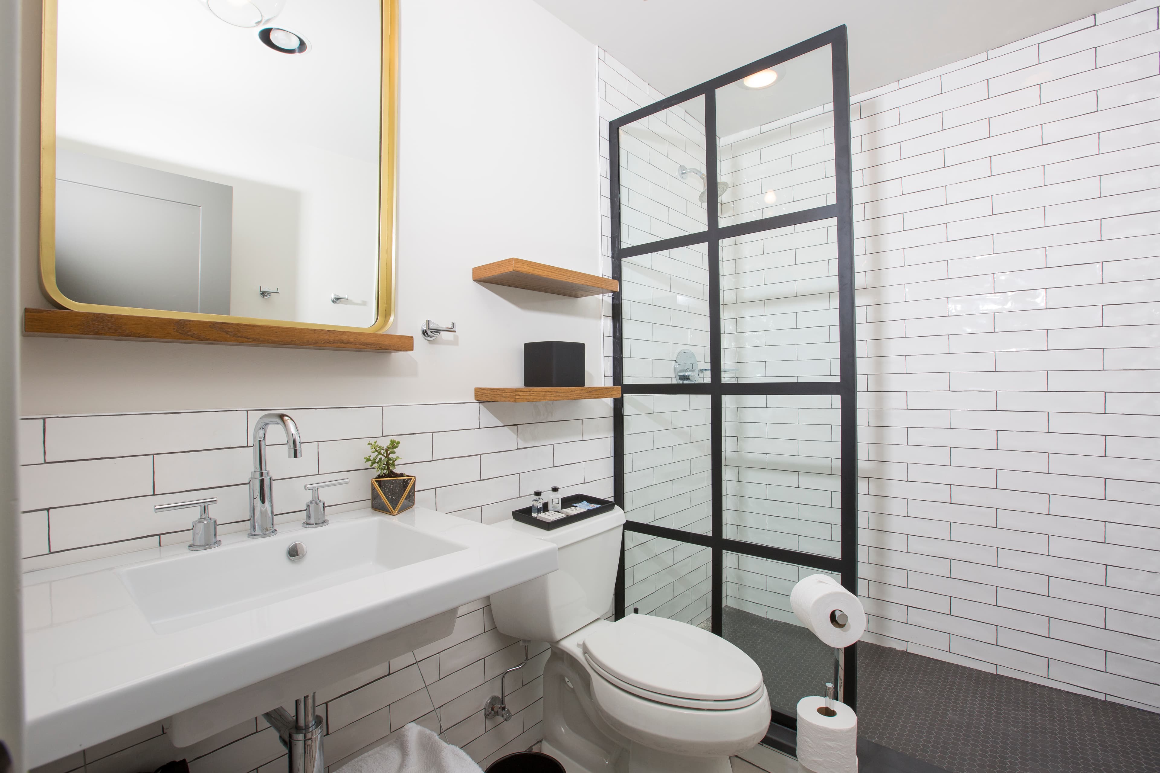 The Hoyne King bathroom, including shower with glass door, toilet, fluffy towels, sink and complimentary toiletries