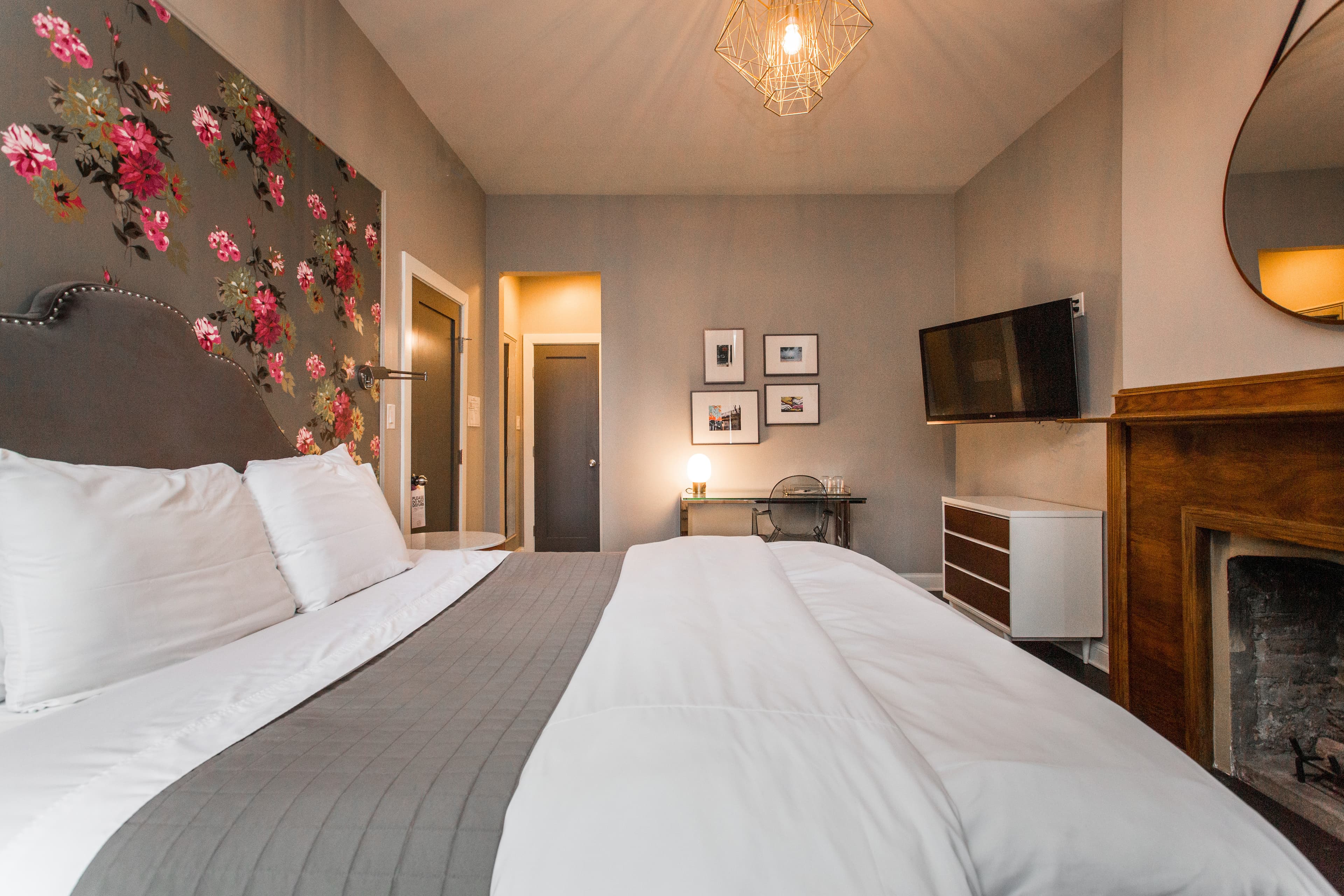 The Hoyne King bedroom, including a sprawling bed and wooden hearth