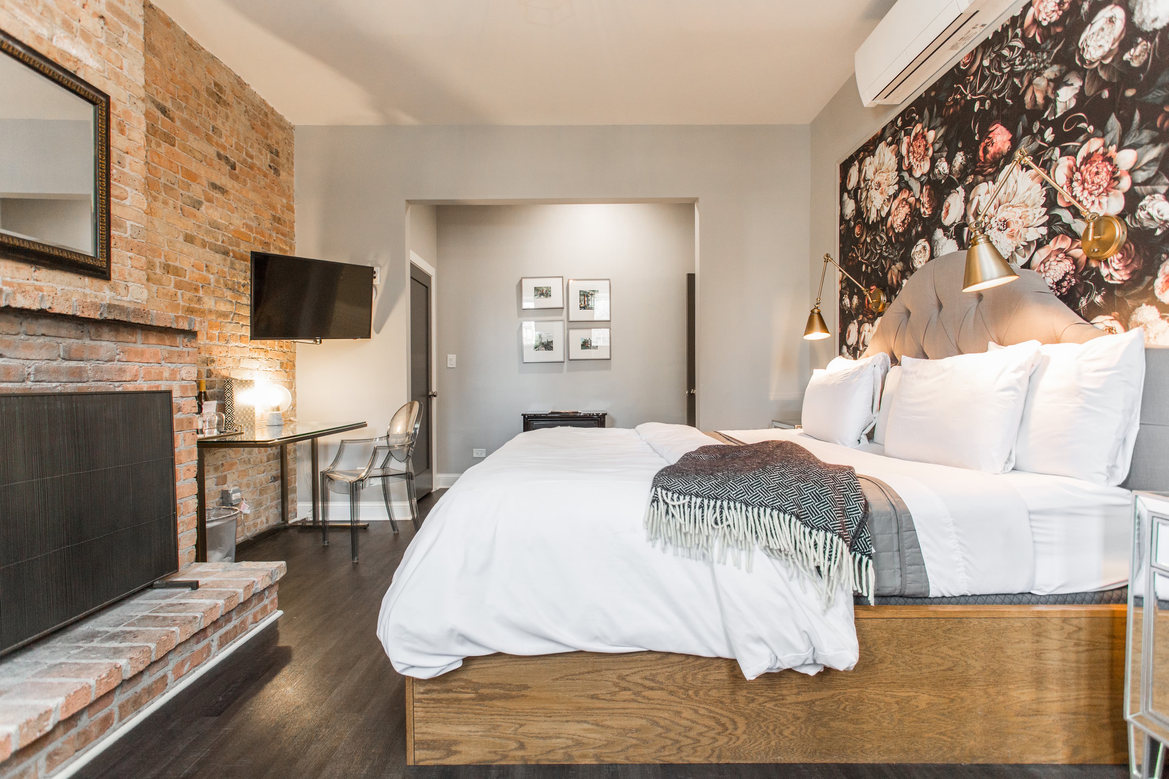 Wolcott King room from the entryway, a spacious room with exposed brick decorative fireplace, wooden mantle and ensuite bathroom