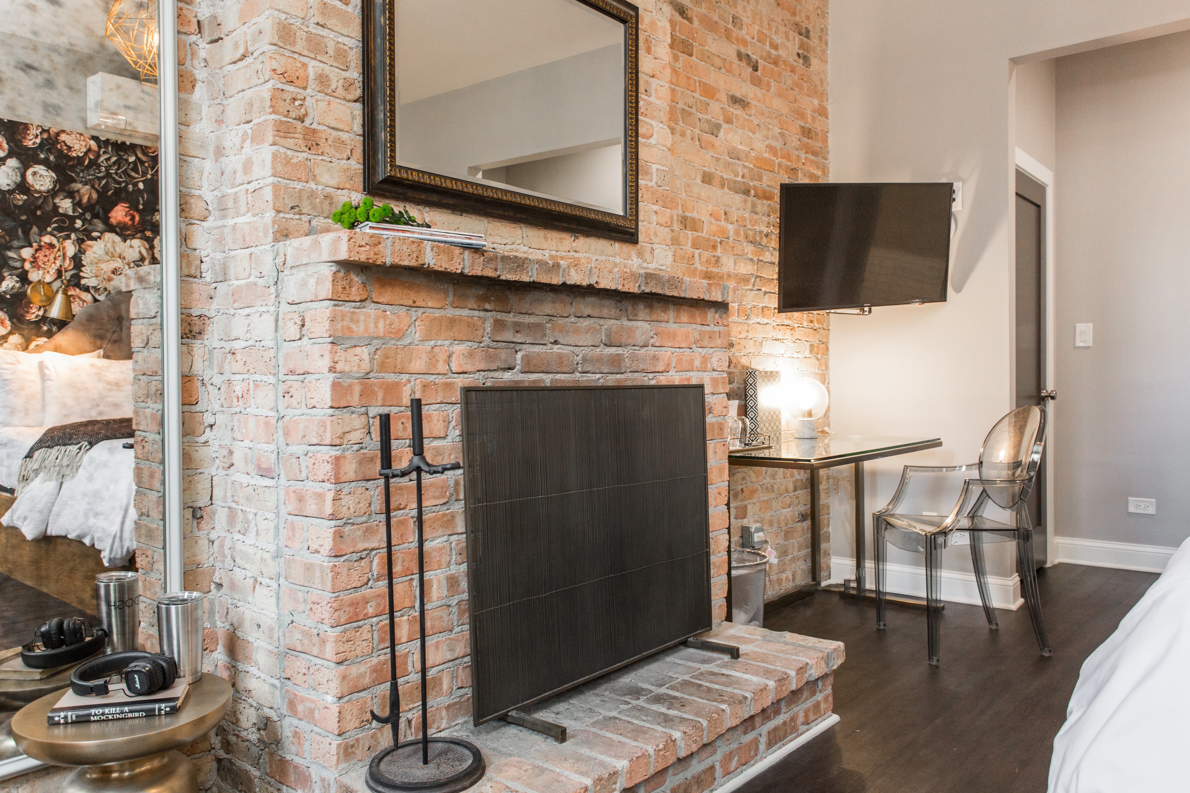 Brick wall with fireplace, desk, and television