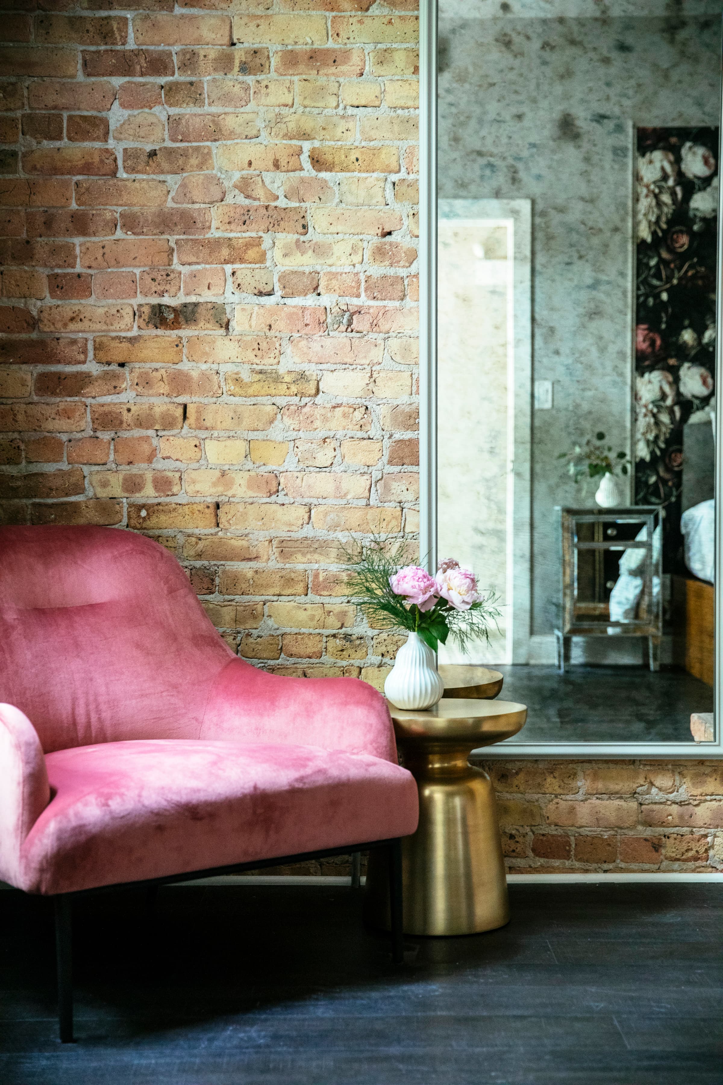 Wolcott's plush pink armchair and brass end table with flowers