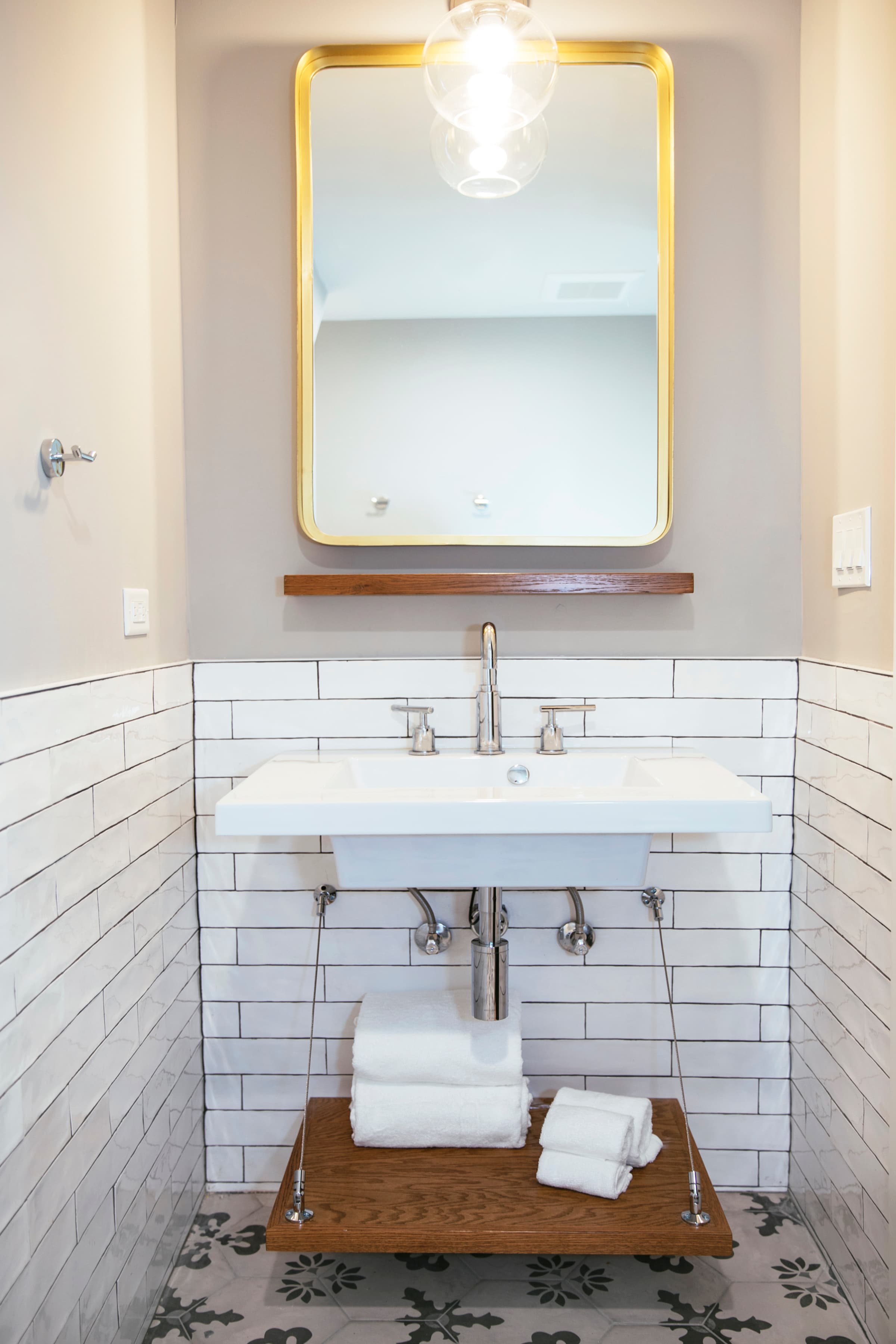 Wolcott's wide sink with fluffy towels stored underneath on wooden shelf