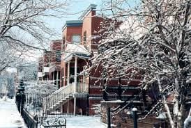 Snow-covered street with red brick houses and bare trees. Snow-covered street with red brick houses and bare trees.