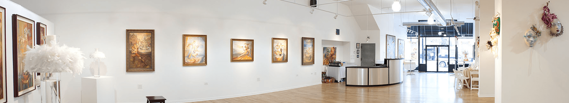 A bright art gallery featuring framed paintings on a white wall with modern decor.