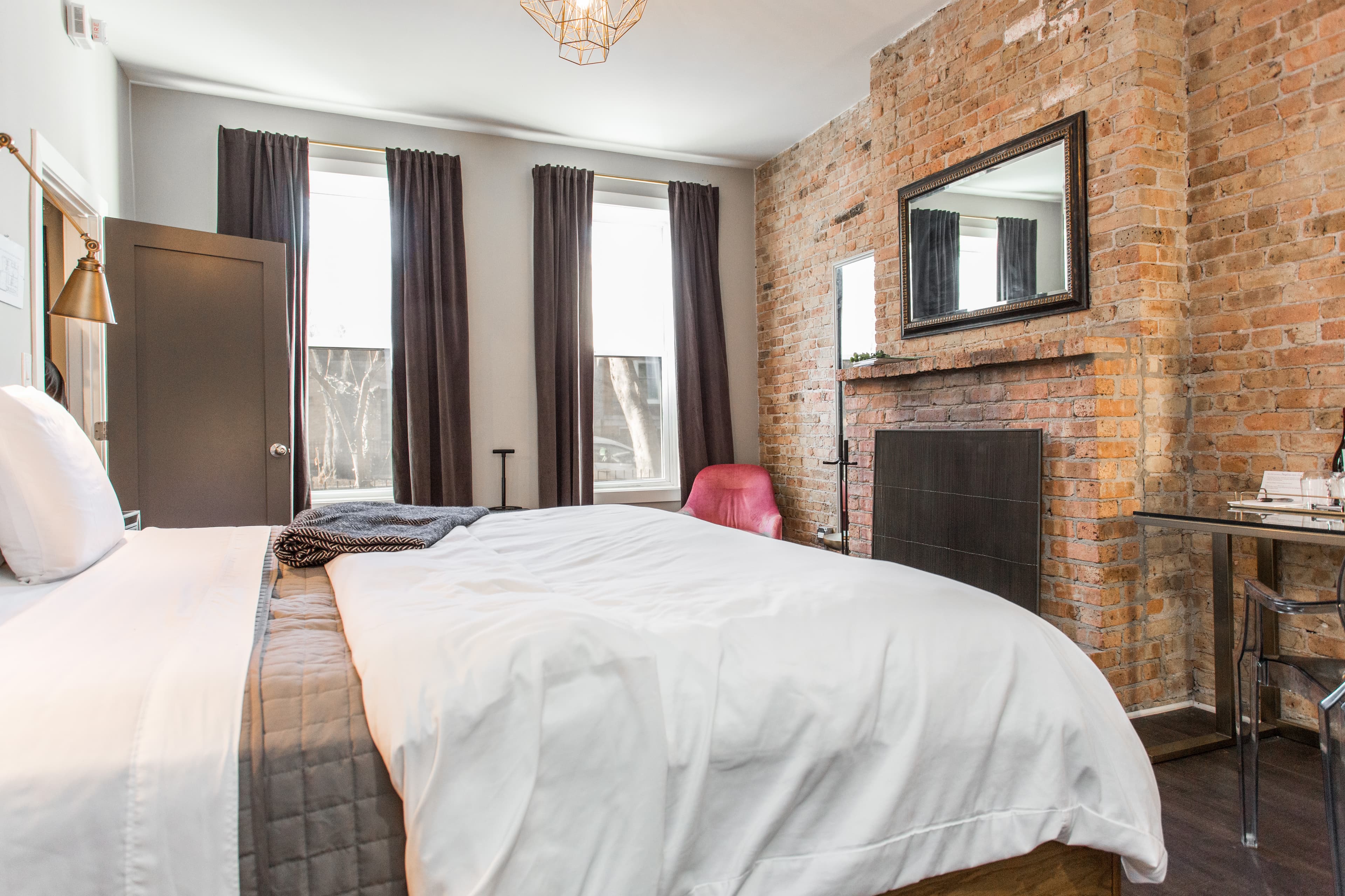 Wolcott from the foot of the bed, showing dresser drawer with flowers, ensuite bathroom and local artwork