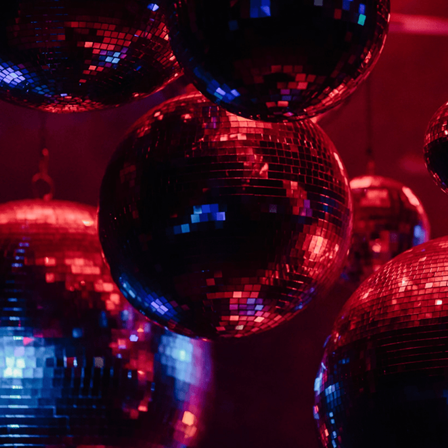 Colorful disco balls hanging against a dark, illuminated background.