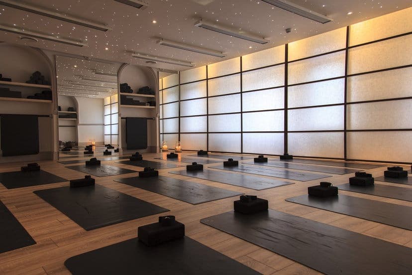 A spacious, serene yoga studio with neatly arranged mats and soft lighting.