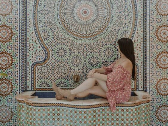 girl outstretched on mosaic tiled water fountain